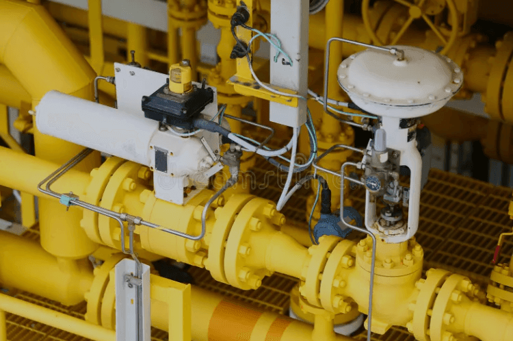 Close-up of industrial gas pipeline system with yellow pipes and control valves.